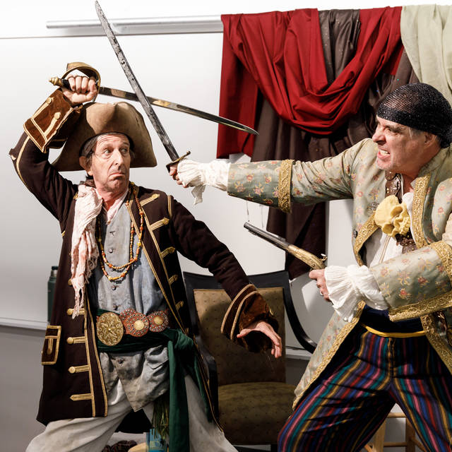 models dressed as pirates pose in sword fight