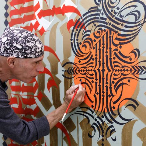 /@petergrecoart painting the Integrated Studies mural.