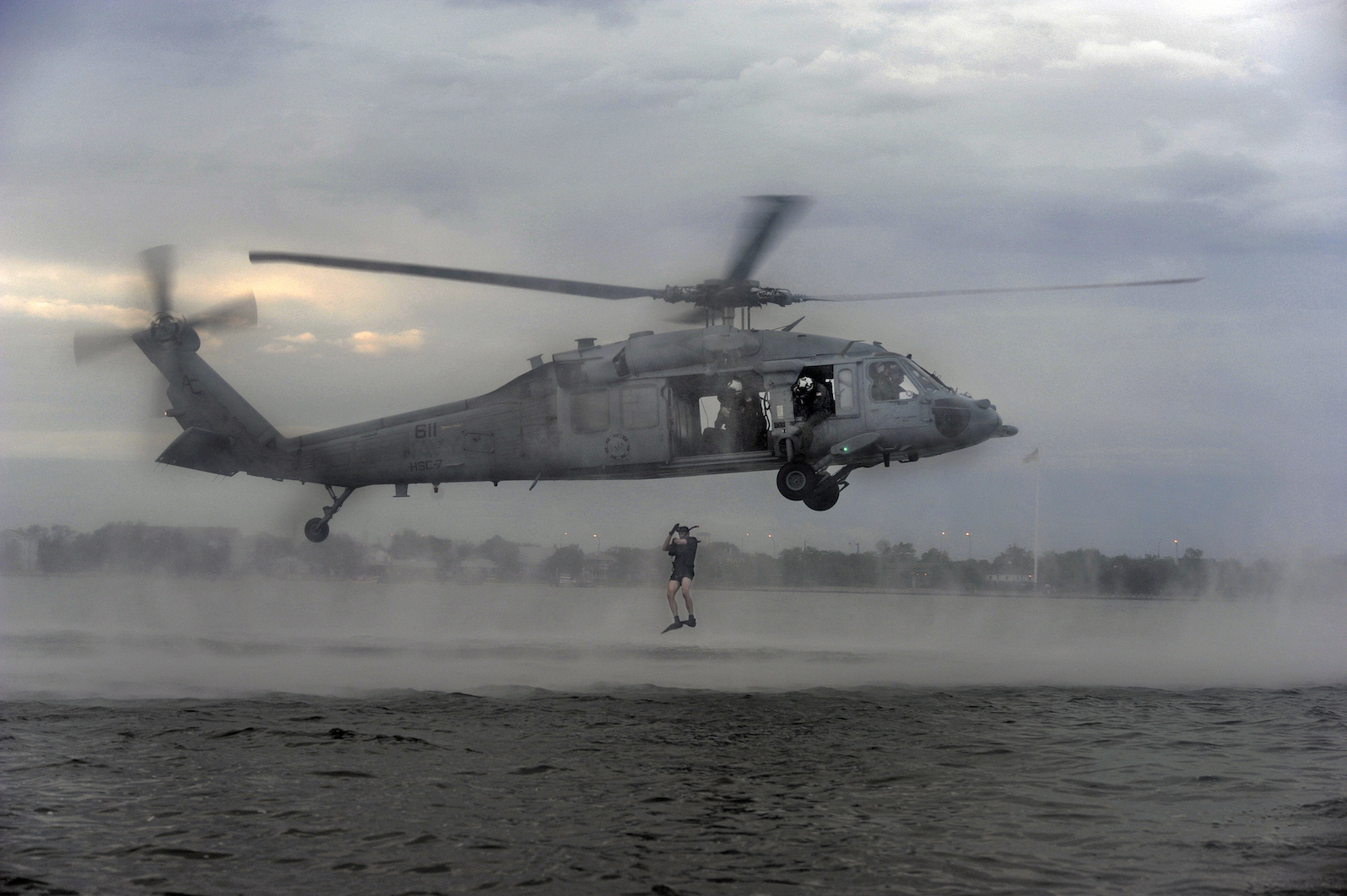 In this photo by Christopher Stoltz, members of Helicopter Sea Combat Squadron Seven (HSC-7) perform search and rescue jumps for qualification at Naval Station Norfolk in 2011.