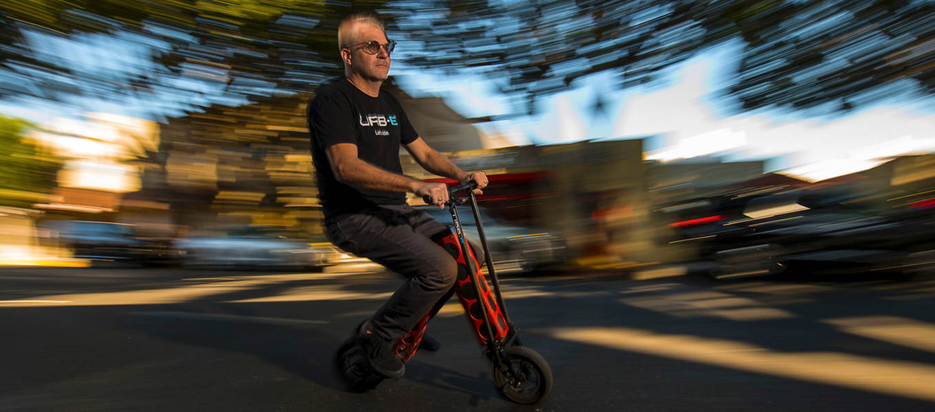 Photo of ArtCenter alumnus and URB-E cofounder Grant Delgatty riding an URB-E foldable electric scooter