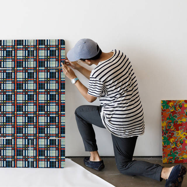 male student applying patterned fabric to a rectangular board