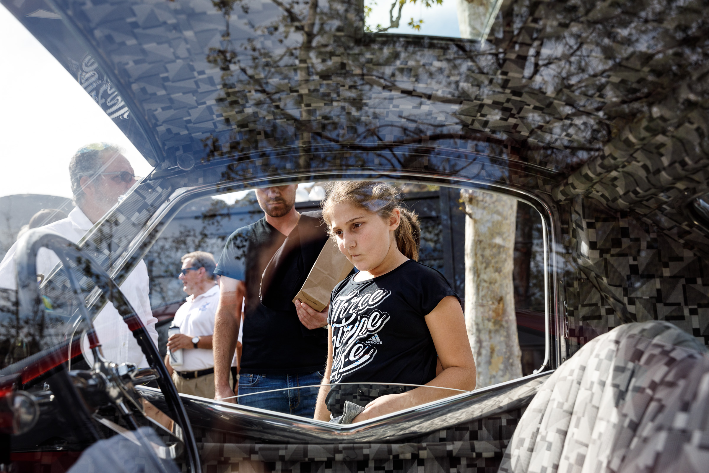 Photo of a young girl looking at a car during Car Classic 2018.
