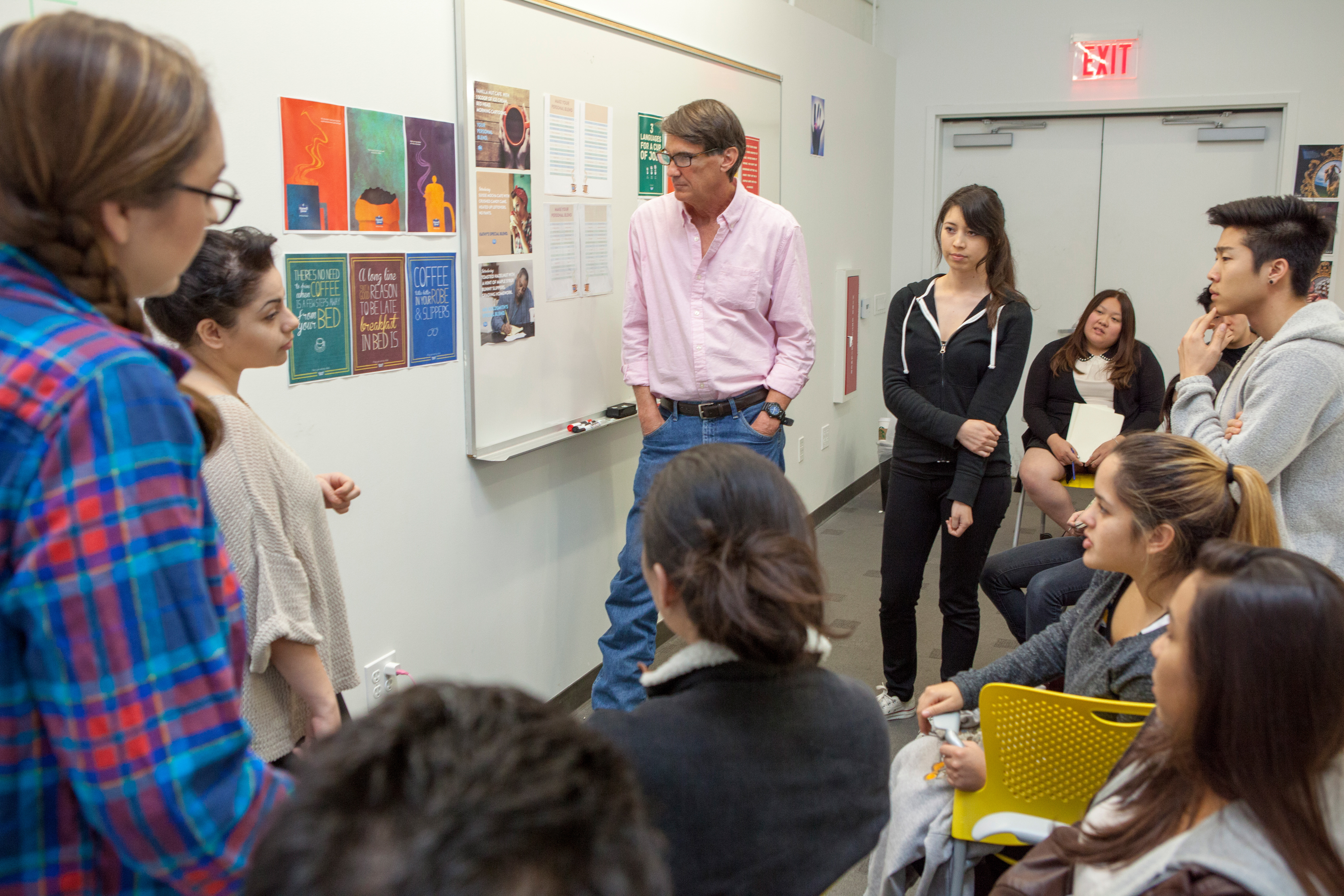 Students and Gary Goldsmith review work during a Crashvertising session..