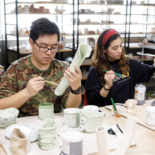 students painting their handmade ceramics