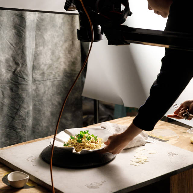student photographing a plate of noodles from above