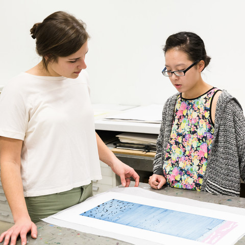Two students discuss an art print