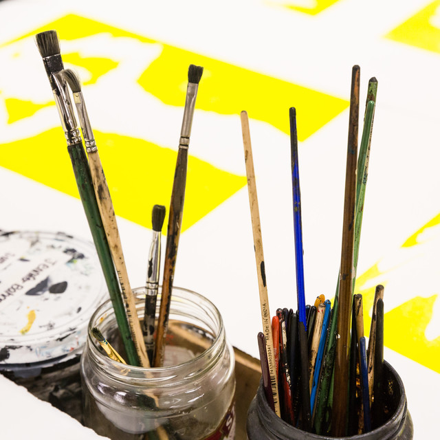 paint brushes in glass jars