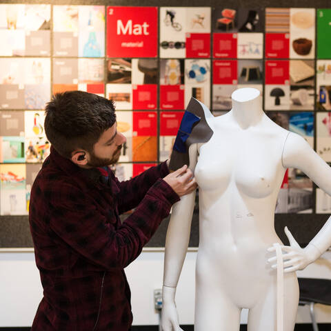 /student pinning fabric on a mannequin