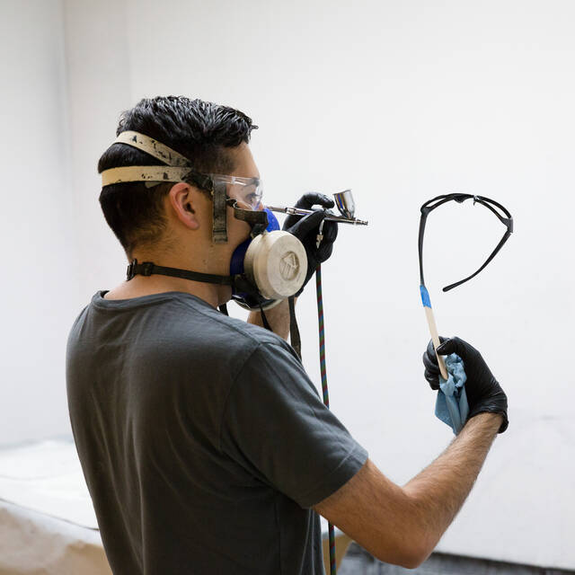 /man wearing a breathing mask and air-brushing eye glasses