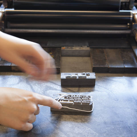 /hands placing letterpress type