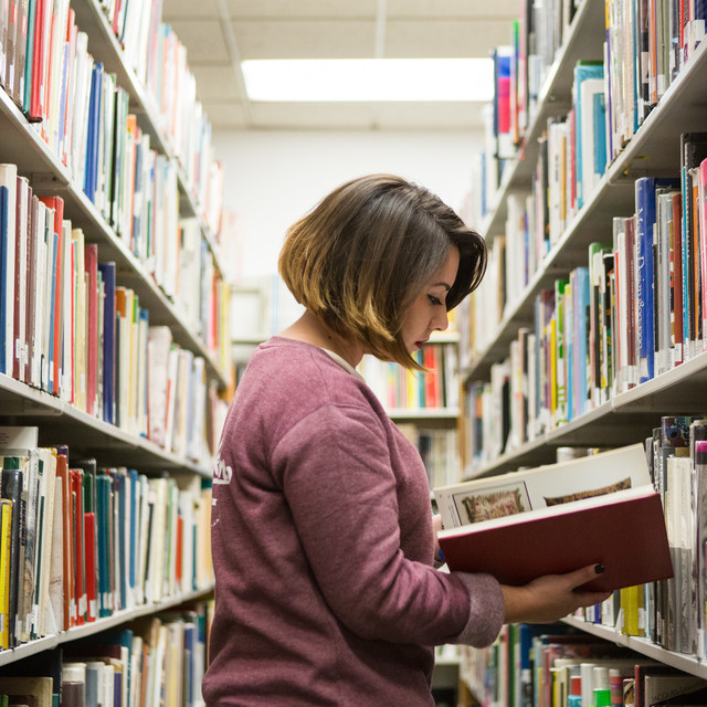 An ArtCenter student browses books in the college library stacks