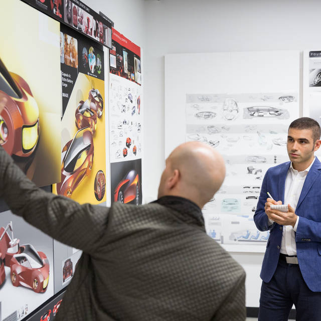 An ArtCenter Transportation Design student and faculty member discuss the students project 