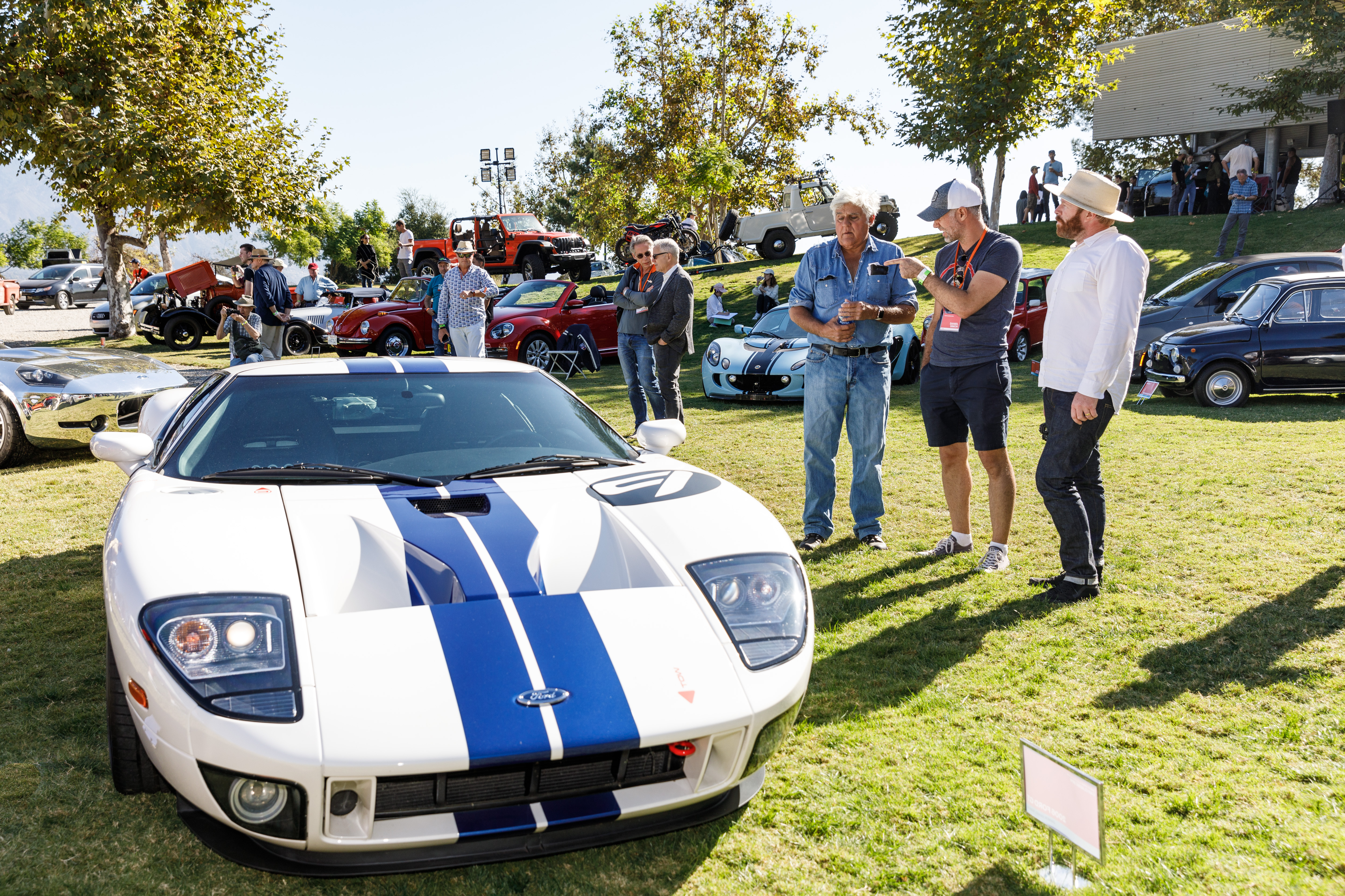 Photo of Jay Leno and others admiring a vehicle at Car Classic 2019.. 