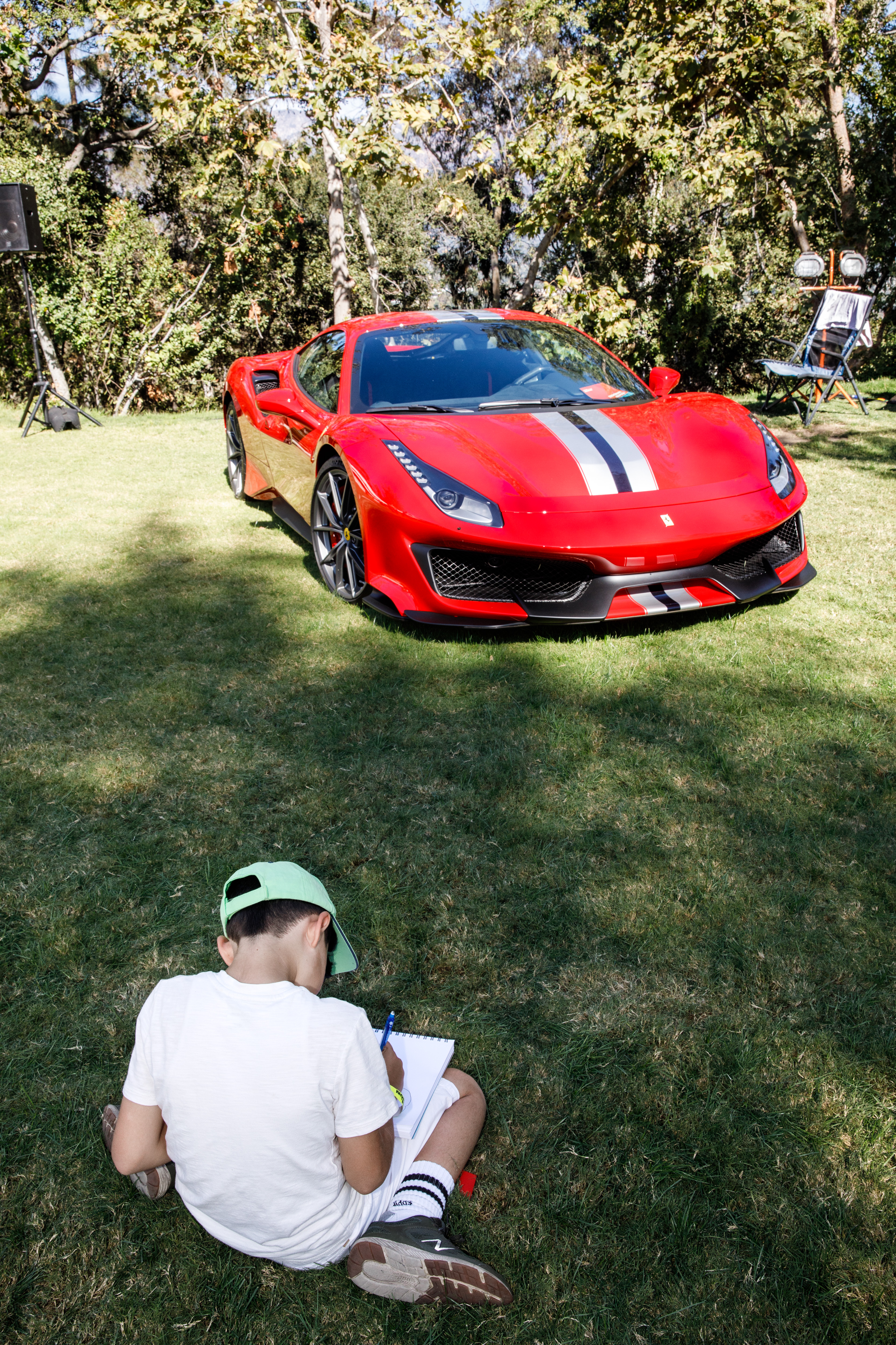 Photo of a child sketching a car on display at Car Classic 2019.