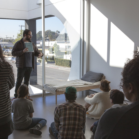 A man presents an art piece in the loft of the 870 building