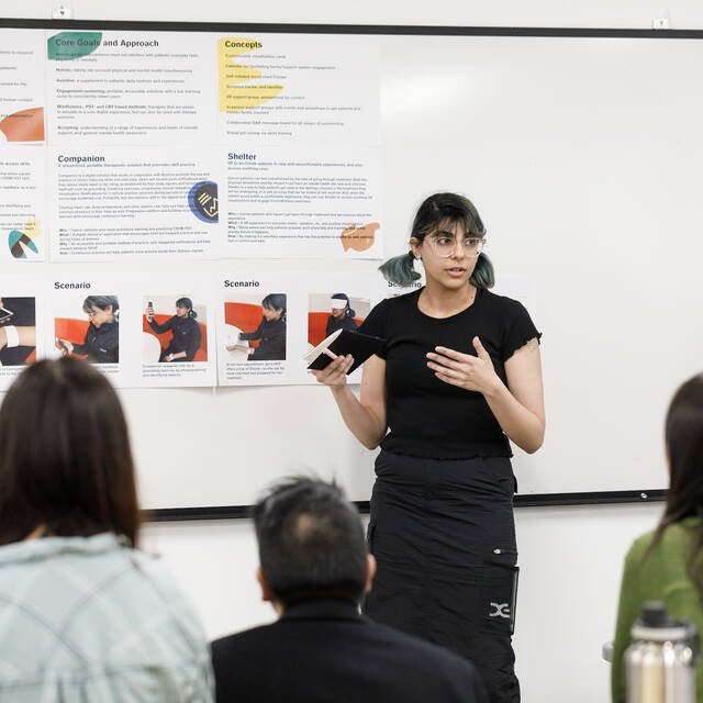 Student presenting project posters to peers