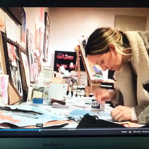 /Blonde woman works on collage with art materials on desk