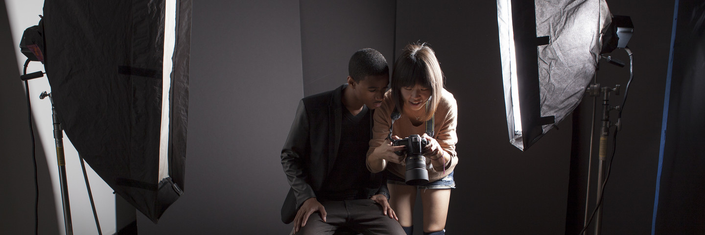 student photographer and model review images on the back of a digital camera