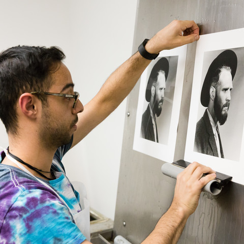 An ArtCenter student looks over his photo prints