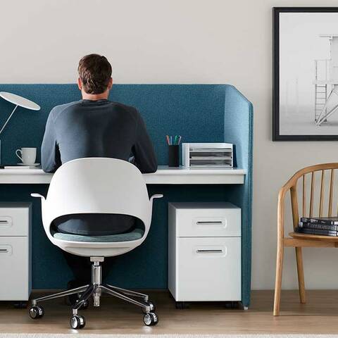 /Photo of an office setting from the back, desk, chairs, lamp and art on the wall.