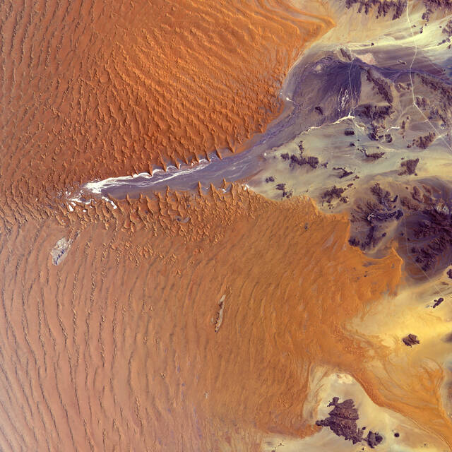 At+fifty-five+million+years+old%2C+the+Namib+Desert%2C+in+western+Namibia%2C+is+considered+the+oldest+desert+on+Earth.+In+this+image+part+of+the+Namib-Naukluft+National+Park+is+visible%2C+which+covers+an+area+of+almost+50%2C000+square+kilometers+%2819%2C300+square+miles%29.+The+park%E2%80%99s+main+attraction+is+Sossusvlei%2C+a+large+white+salt+and+clay+pan+in+the+center+of+the+image.+Sossusvlei+is+a+basin+for+the+Tsauchab+River%2C+an+ephemeral+river+flowing+from+the+east.+The+dunes+in+this+area+are+some+of+the+highest+in+the+world.+The+tallest+stands+at+around+325+meters+%281%2C066+feet%29.+The+Namib+Sand+Sea+is+the+only+coastal+desert+in+the+world+to+contain+large+dune+fields+influenced+by+fog%2C+the+primary+source+of+water.