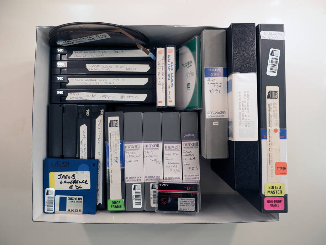 A photo of a box filled with videotapes, floppy disks, and CDs from LACMA