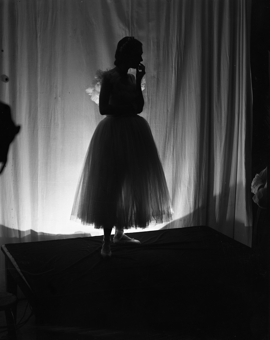 Silhoutted against a curtain, Model Lileth Stanwood poses for a photo shoot, circa 1935. Photograph by Irene Gutterman (2003.2.110).