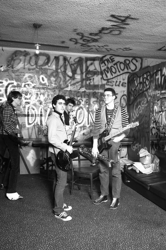 Jules Bates photograph of Dickies at the Whisky (black and white image of a woman leaning against a wall, 4 men with musical equipment and graffitied walls)