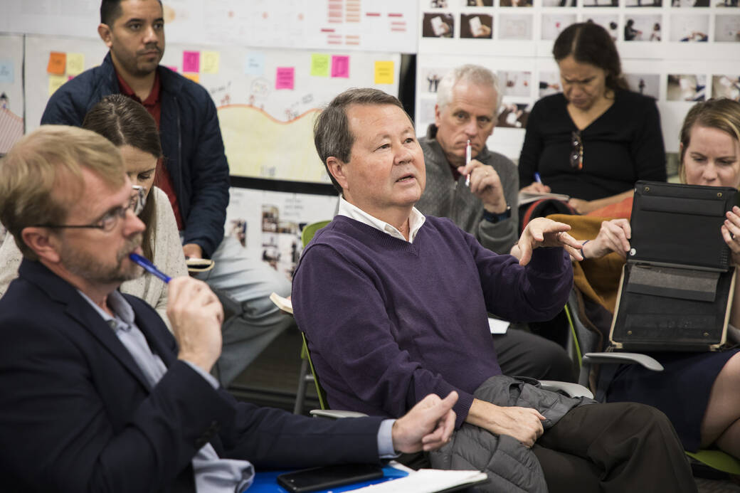 Dr. Robert Haile, director of the Cancer Research Center for Health Equity at Cedars-Sinai Medical Center, provides feedback following a student presentation, while seated and surrounded by ArtCenter students, faculty and staff.