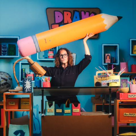 /woman holding giant pencil