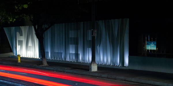 Nighttime photo of illuminated exterior signage of Mullin Gallery 