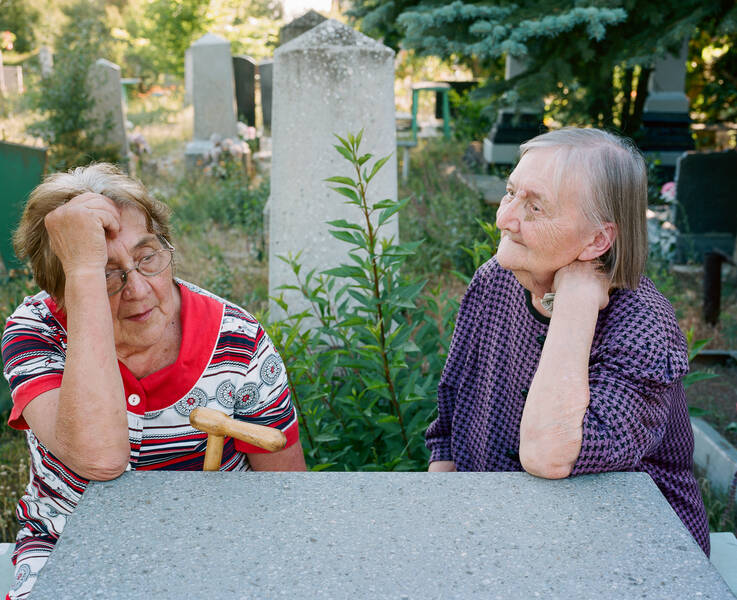 Stella+Kalinina%27s+great-aunt+and+grandmother+visiting+family+members%2C+friends+and+neighbors+at+the+town+cemetery+in+Izium%2C+Ukraine%2C+June+2018.+Photo+by+Kalinina+for+her+project+%3Ci%3EWhere+They+Wait+for+Me%3C%2Fi%3E.