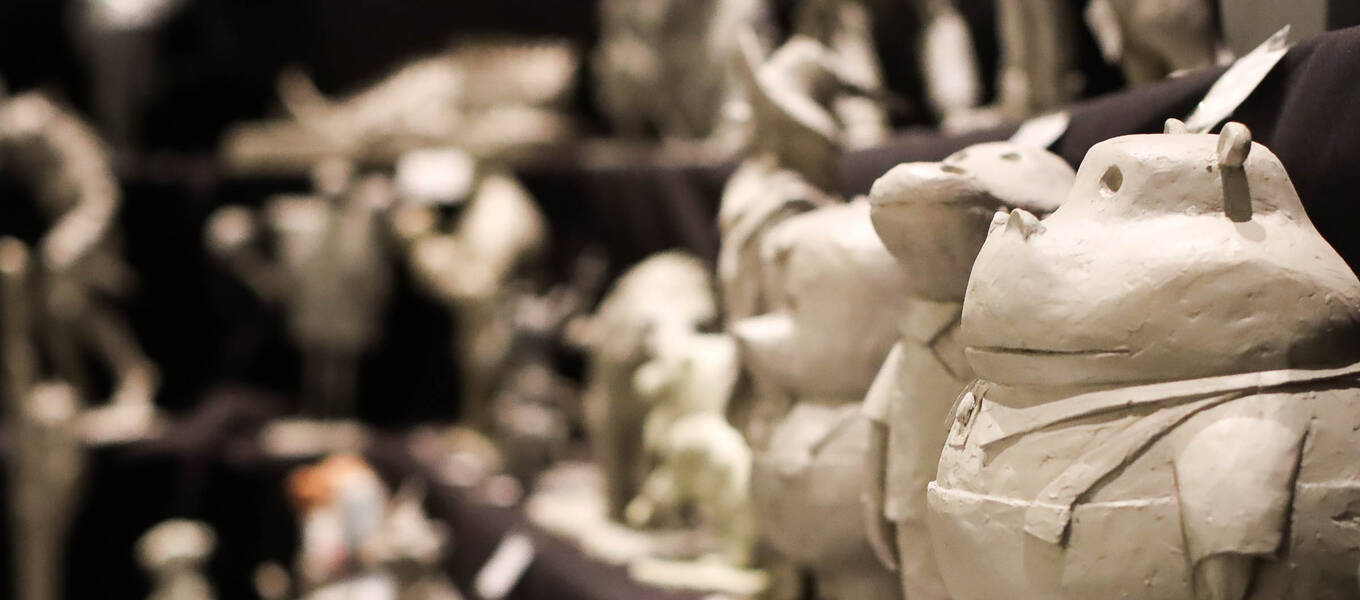 a row of grey clay sculptures at Lightbox Expo