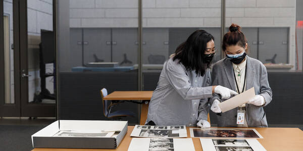 student researchers study artwork in the archive