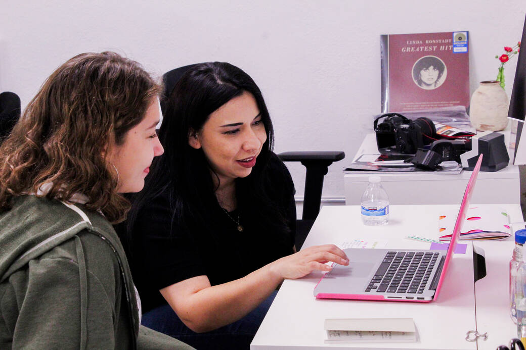 Photography alum Celia Sanchez with a Los Fotos Project student, during a portfolio review at a 2022 Las Fotos Project Night to Network event.