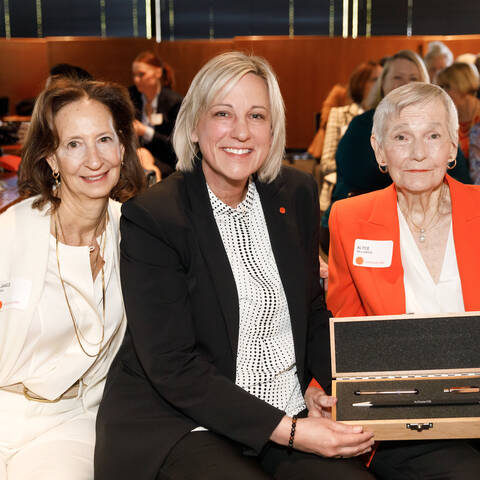 /Current ArtCenter100 President Janice Bea with ArtCenter President and CEO Karen Hofmann presenting the honorary engraved pencil to ArtCenter100 founder Alyce de Roulet Williamson on November 3, 2023 in Pasadena. © ArtCenter College of Design/Juan Posada