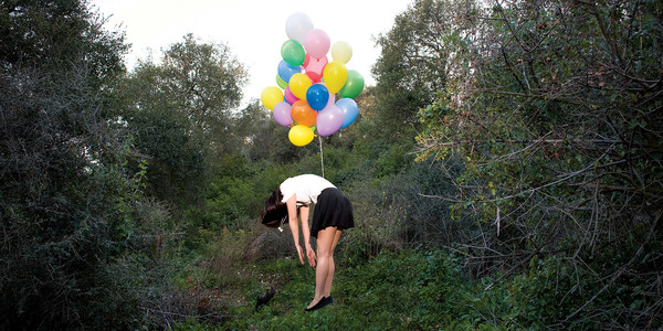 woman floating with balloons