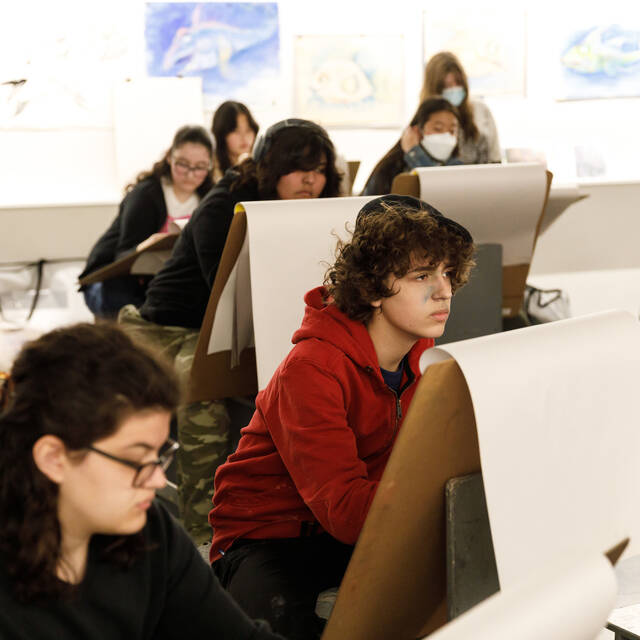  High school students collaborating on art and design projects in a bright, hands-on classroom at ArtCenter.