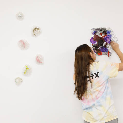 ArtCenter fine art student hanging work on a white wall