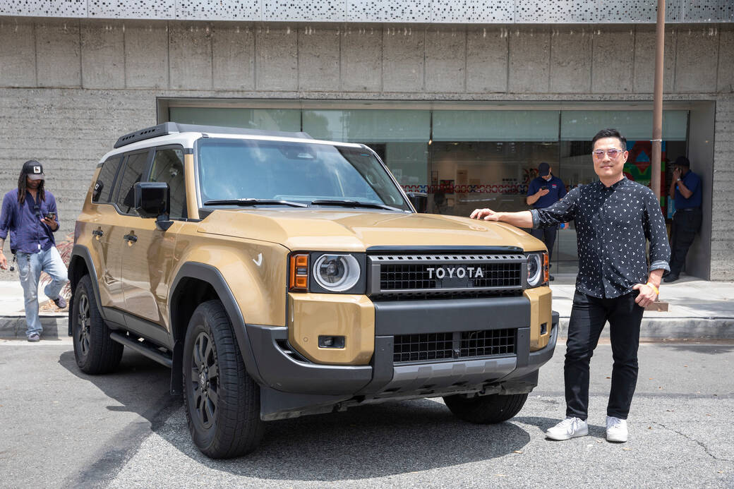 Alum Jin Kim (BS 01), standing with a Trail Dust-colored First Edition of the 2024 Toyota Land Cruiser he designed