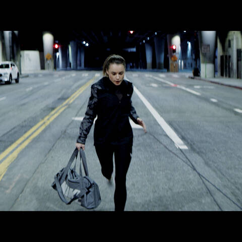 Student+work+of+a+cinematic+render+depicting+a+woman+wearing+Nike+athletic+gear+and+holding+a+Nike+duffle+bag+running+down+the+middle+of+a+street+