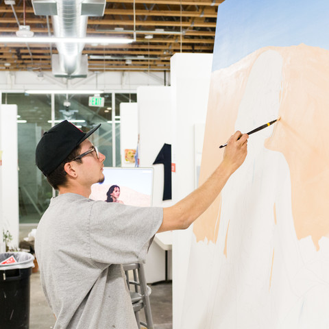 An ArtCenter Fine Art student paints on a large canvas