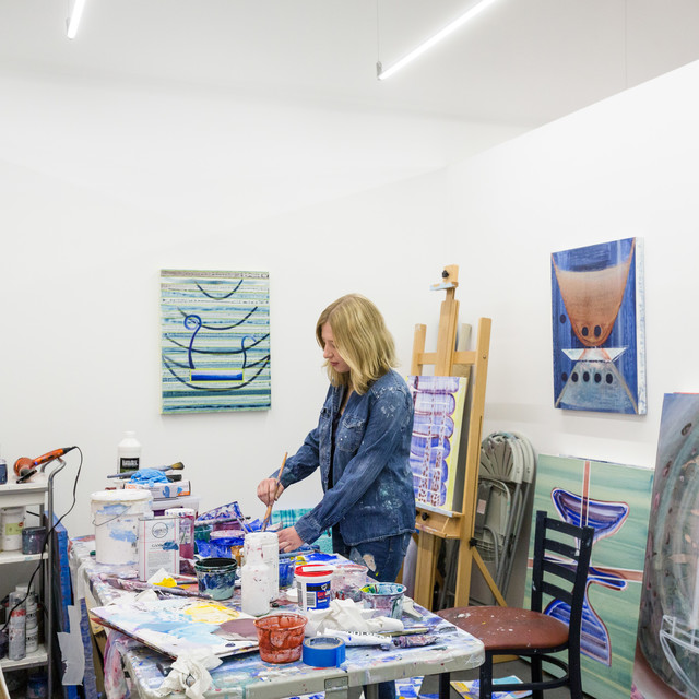 A fine art student works on her paining in the studio