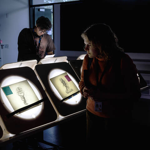 /Person viewing animation sketches at ArtCenter