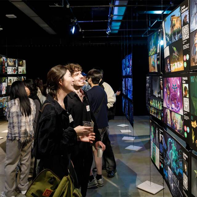 Image of people looking at student work from ENTX 2025.