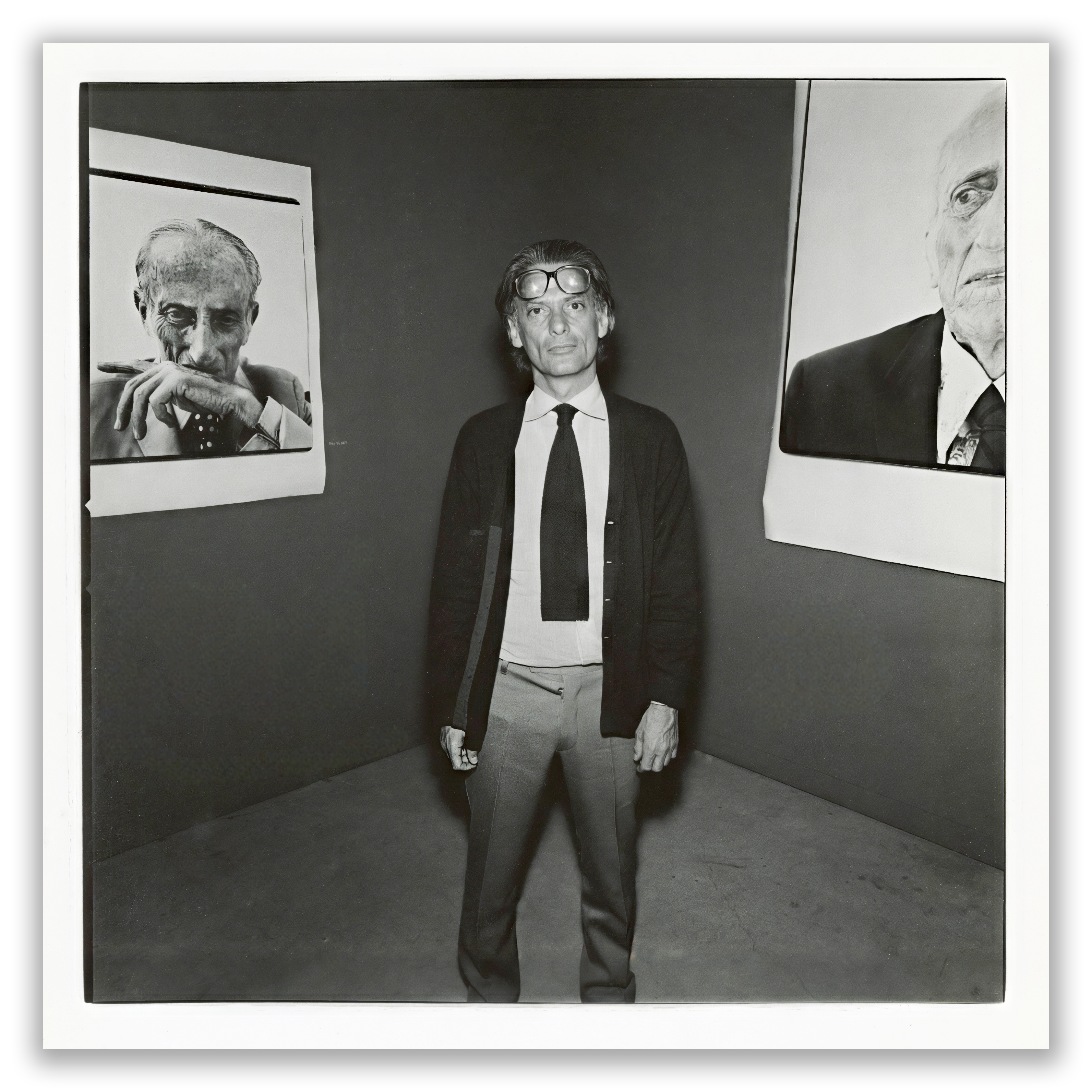 Richard Avedon posing near portraits of his father at his 1976 ArtCenter exhibition. Photograph by Jonathan Simle