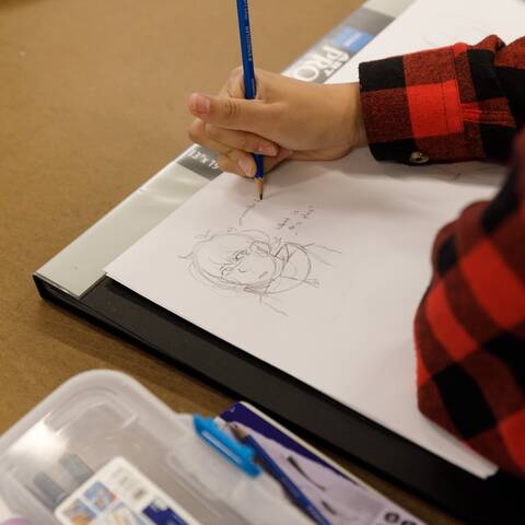 /High school student sketching original characters in Character Design class at ArtCenter Summer Extension, exploring expression, pose, and storytelling.
