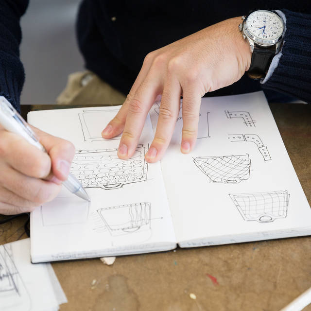 Hands sketching in a notebook