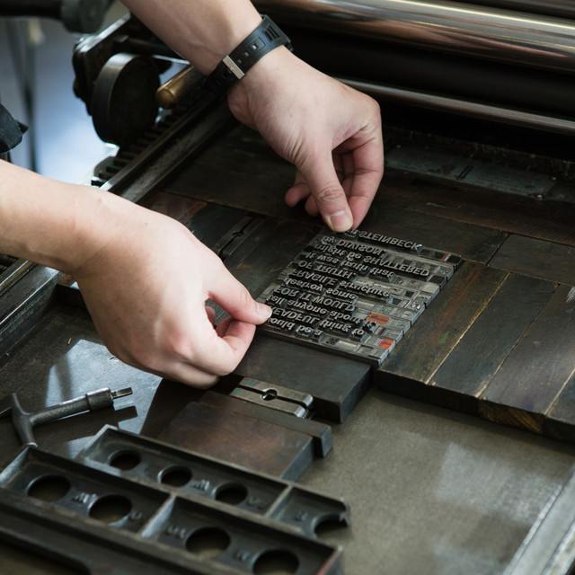 Detail shot of hands setting metal type in the Archetype Press letterpress studio