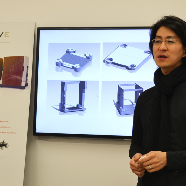 David Day Lee presenting in front of a screen displaying design sketches